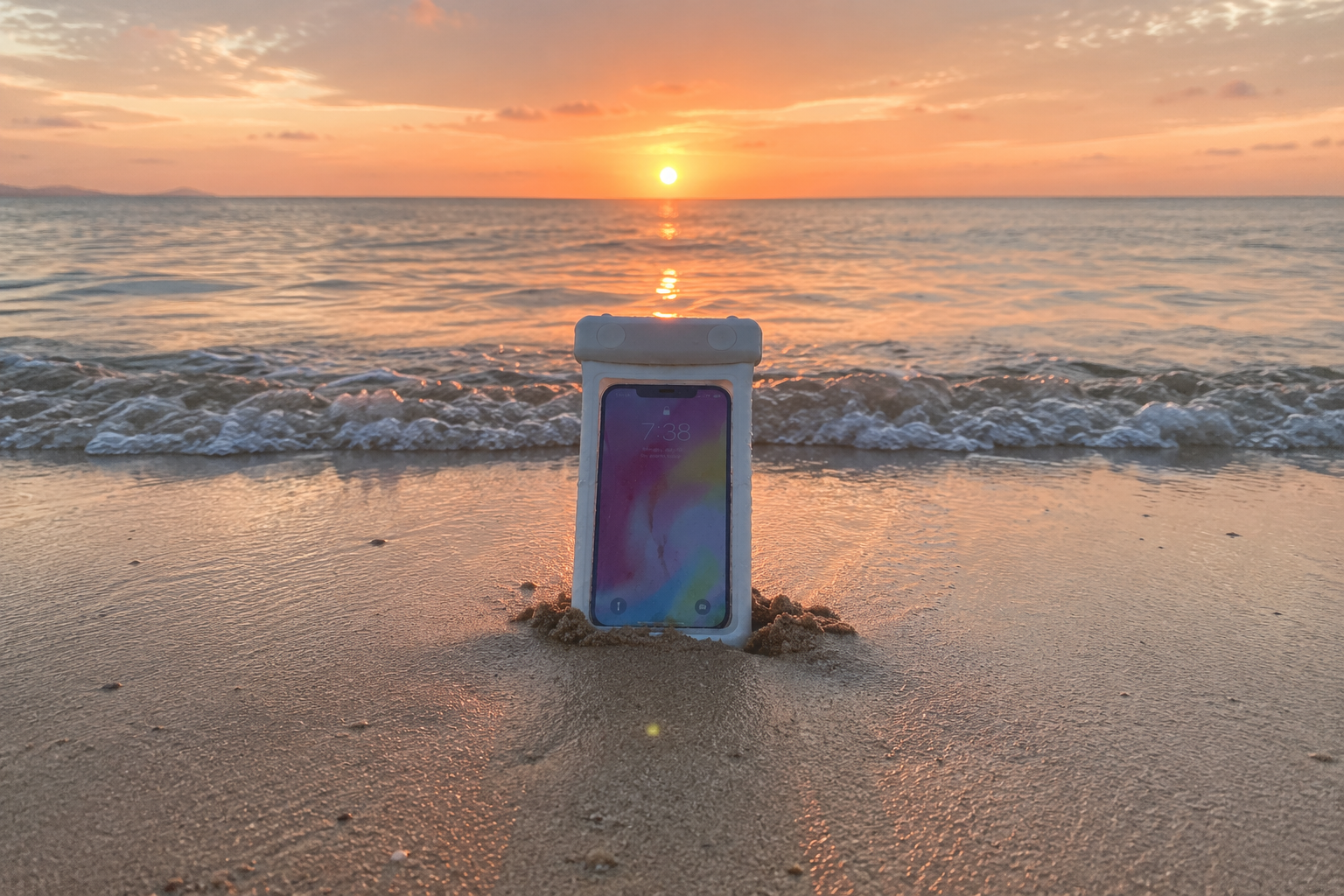 Waterproof phone pouch on the beach at sunset